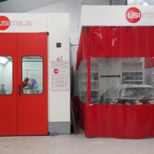 Imagen en primer plano de cabinas de pintura con lona y puerta en color rojo